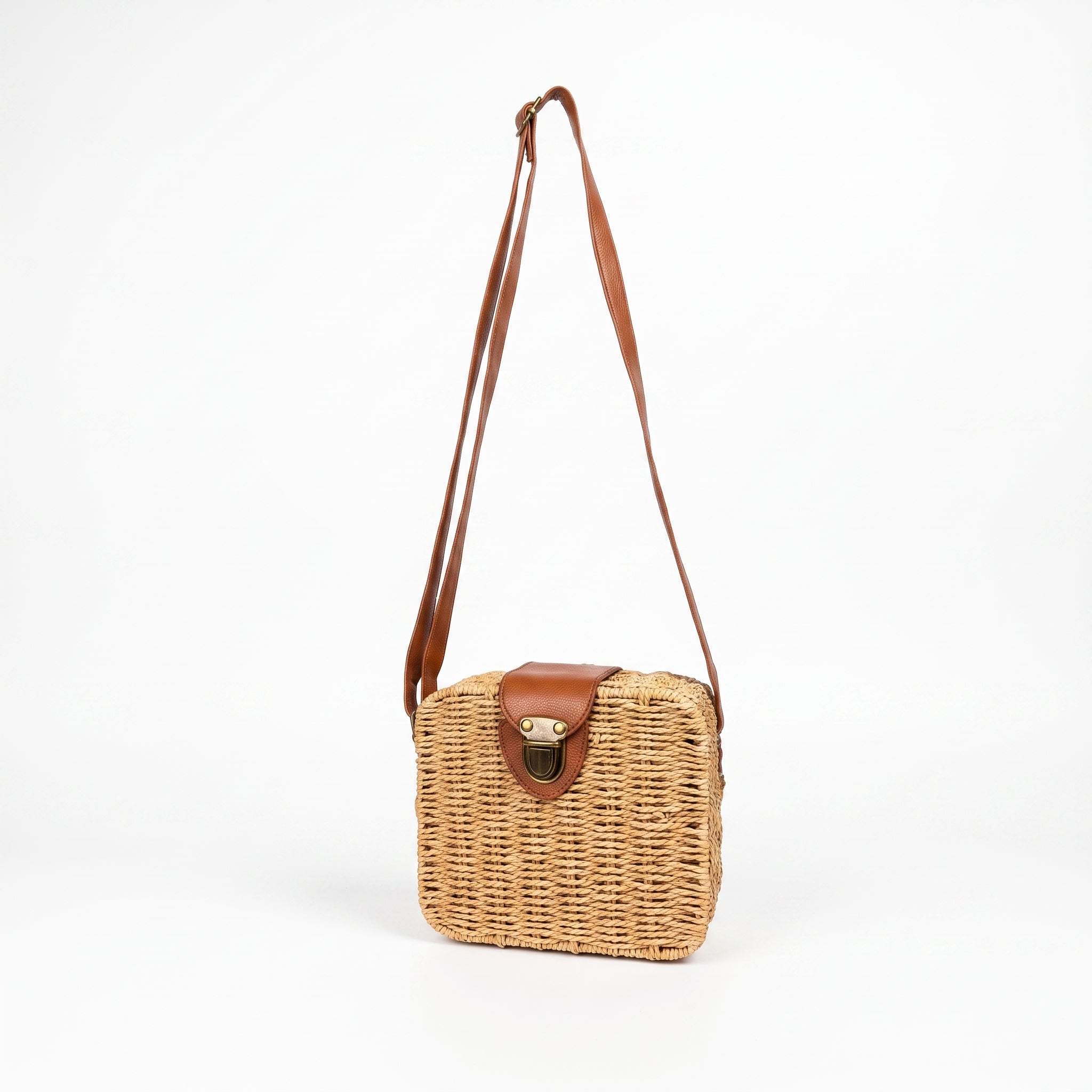 Wicker handbag with brown leather accents on a white background