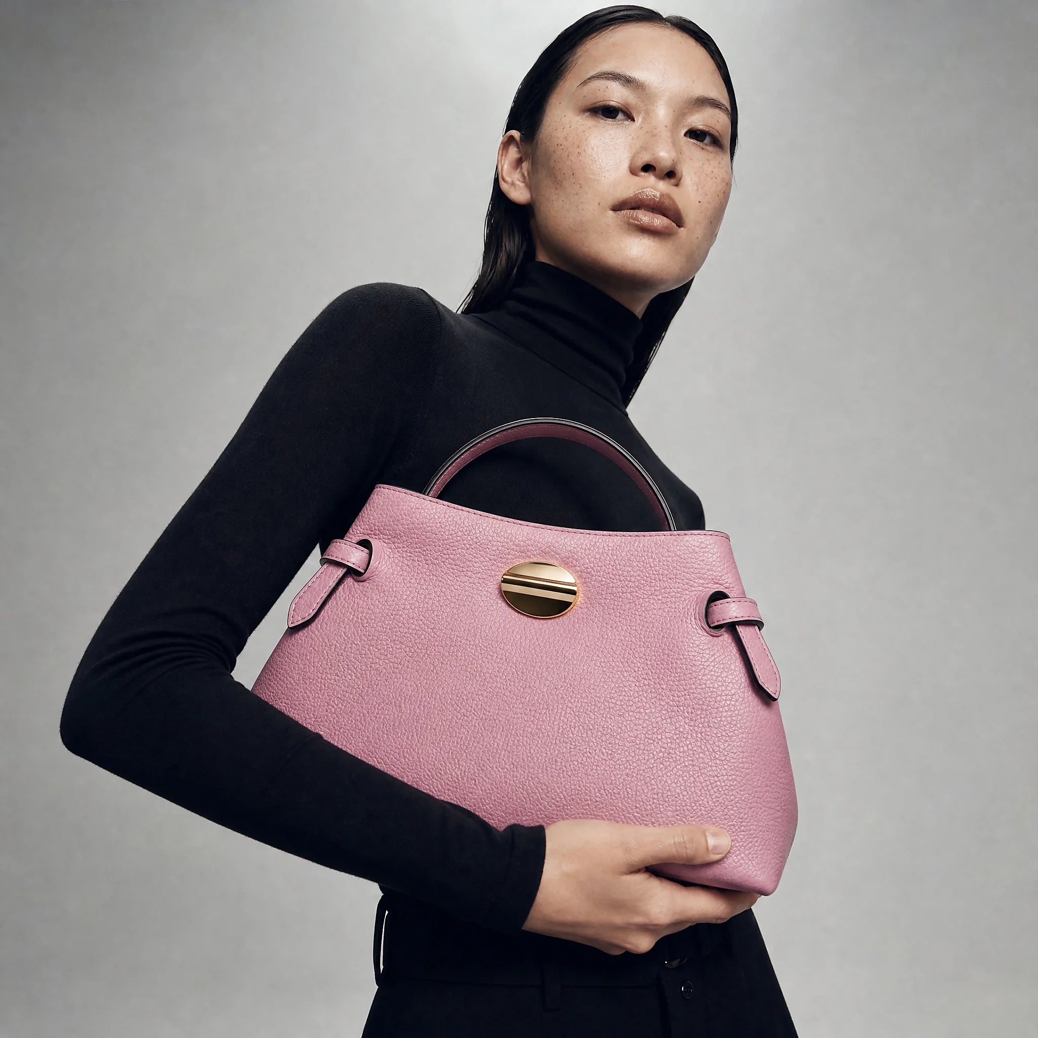 A woman holding a pink bag