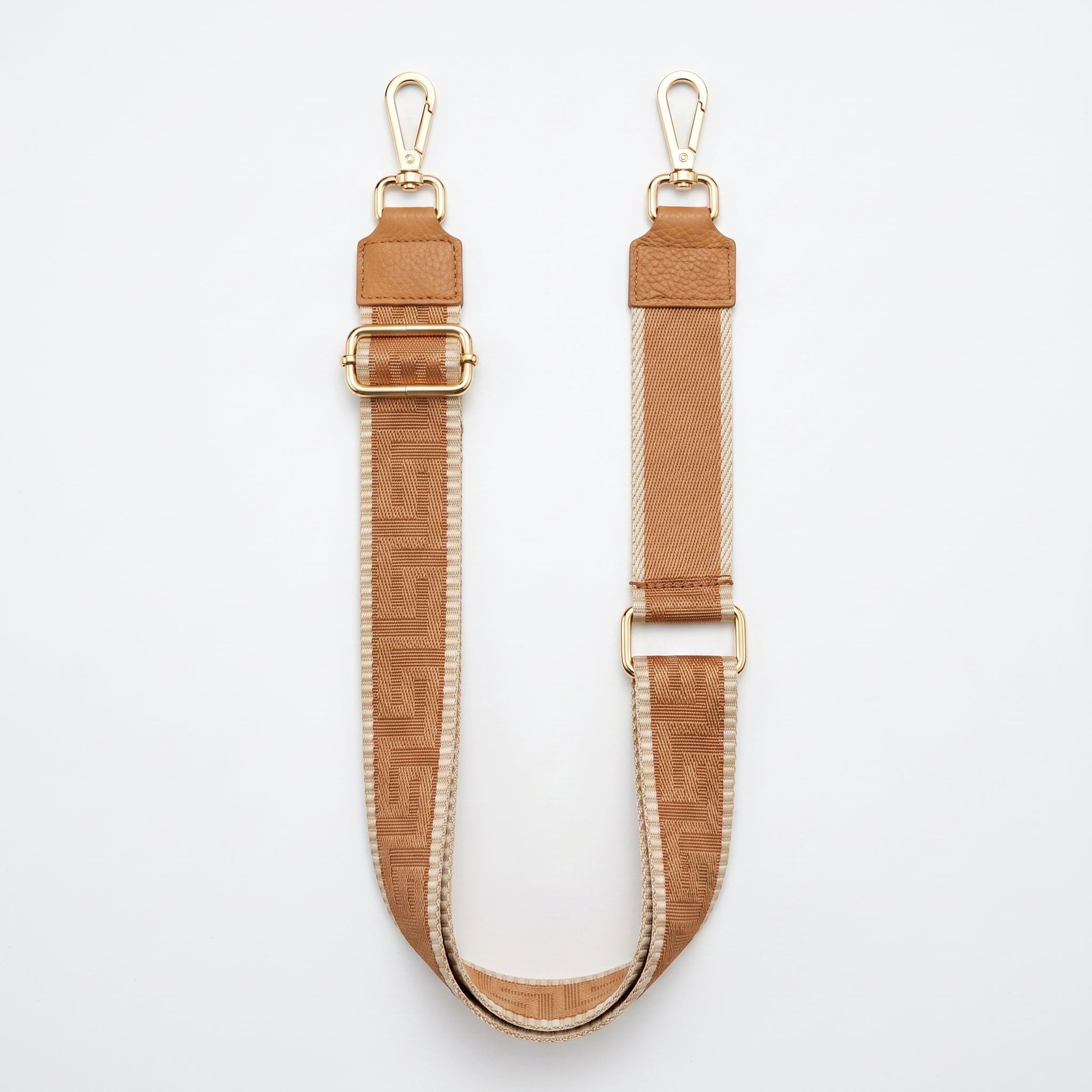 Two brown leather straps with gold hardware on a white background