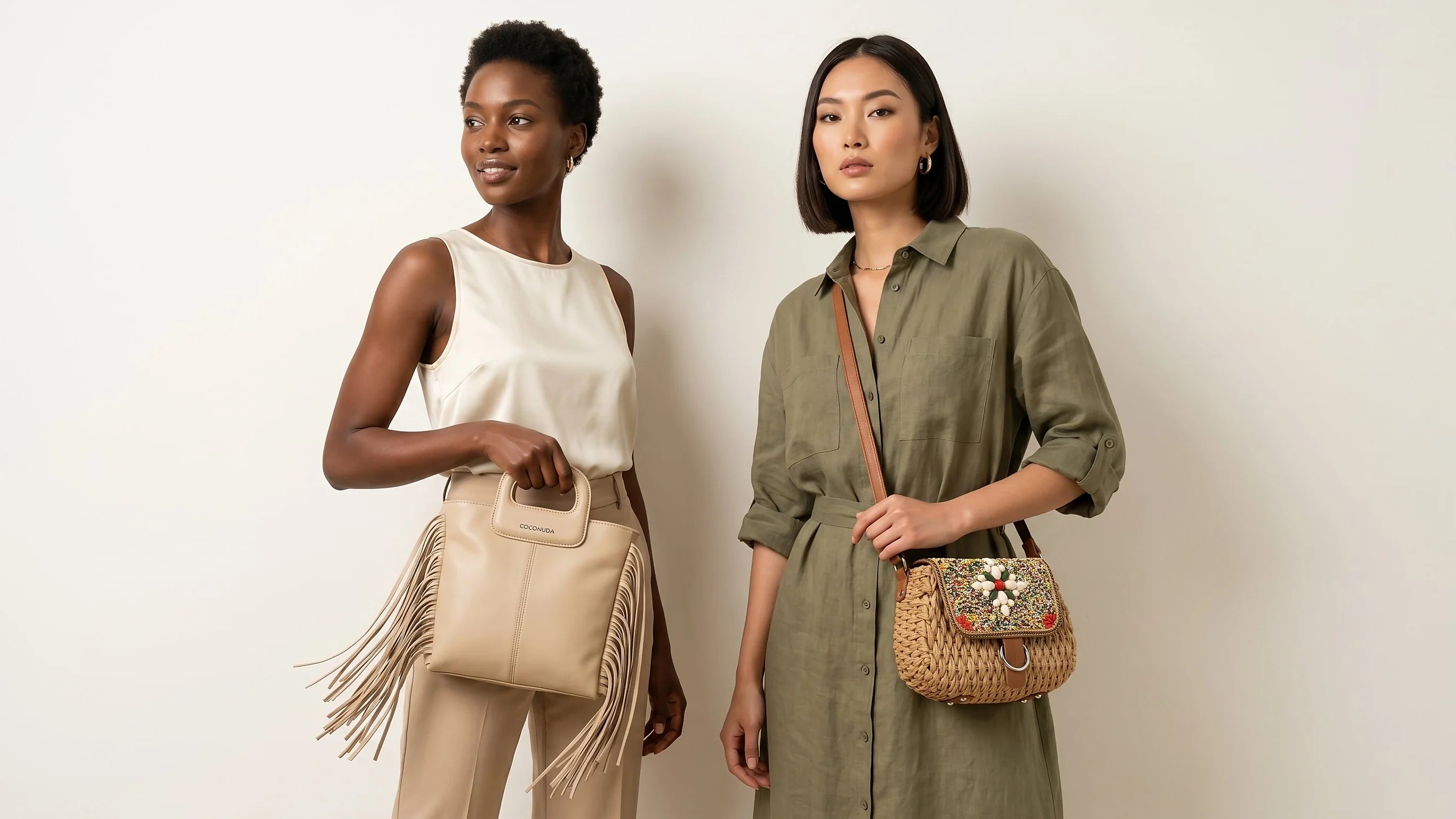 Two women holding handbags against a plain background