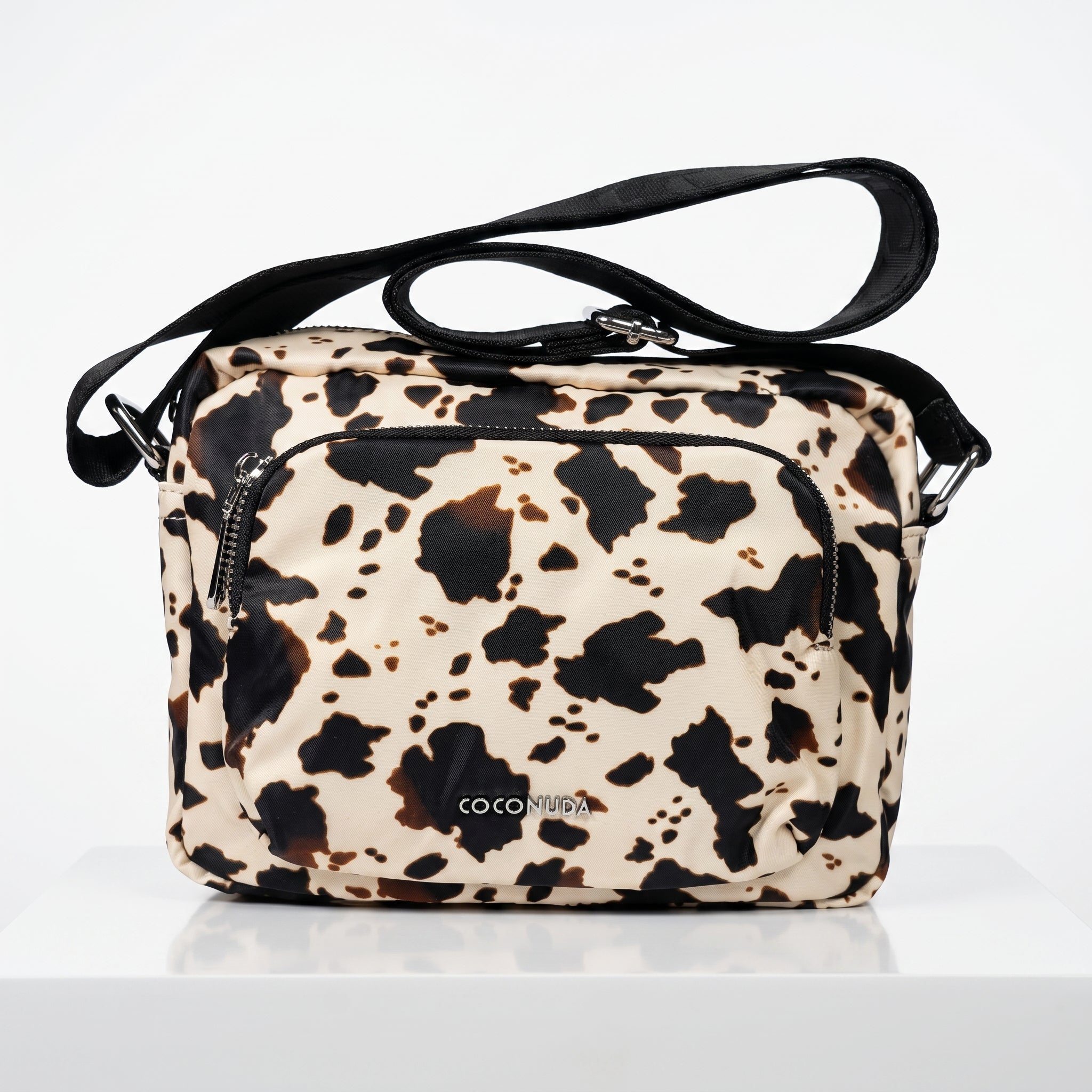 Leopard print handbag with black strap on a white background